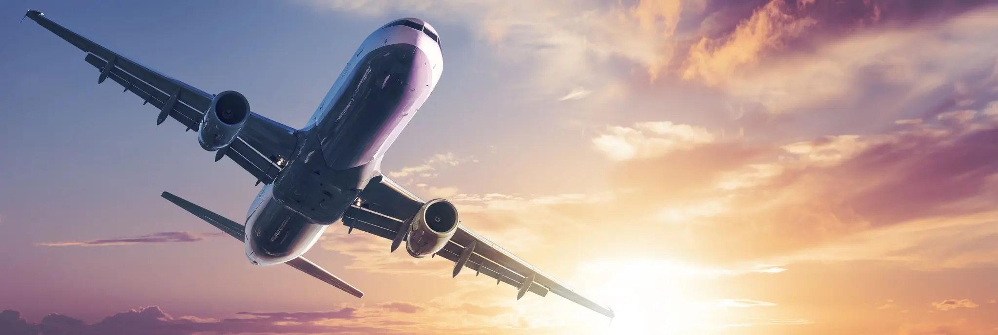 airplane flying into sunset